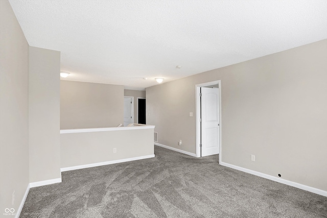 carpeted empty room with a textured ceiling