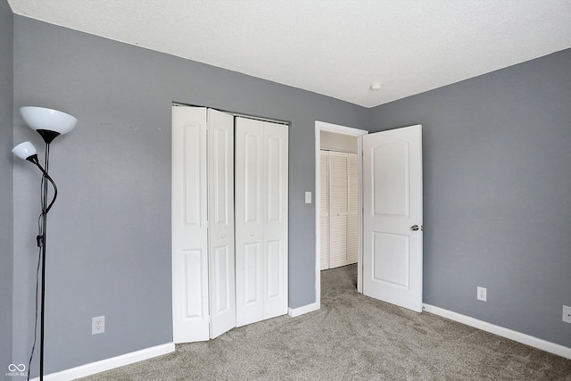 unfurnished bedroom with carpet, a textured ceiling, and a closet