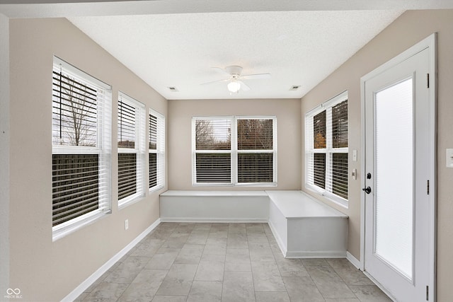 unfurnished sunroom with a wealth of natural light and ceiling fan