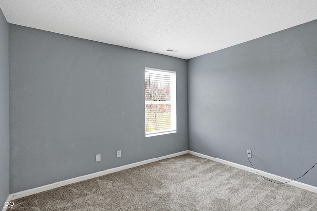 unfurnished room with carpet flooring and a textured ceiling