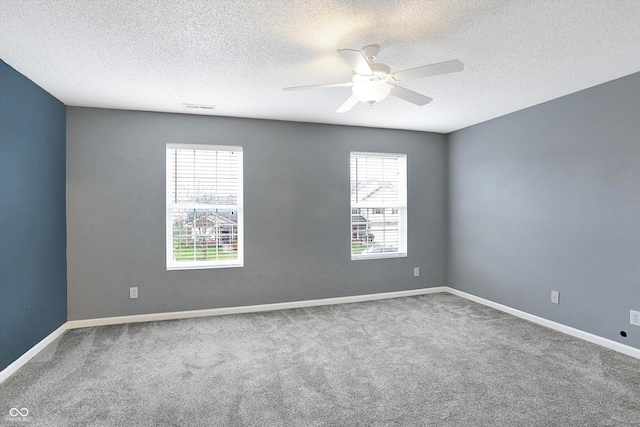 carpeted spare room featuring ceiling fan and a textured ceiling