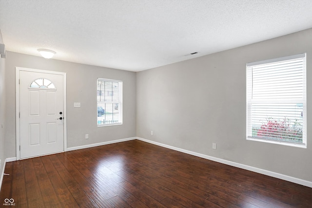 entryway featuring a textured ceiling and dark wood-type flooring