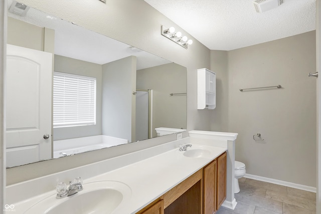 bathroom featuring tile patterned floors, walk in shower, vanity, a textured ceiling, and toilet