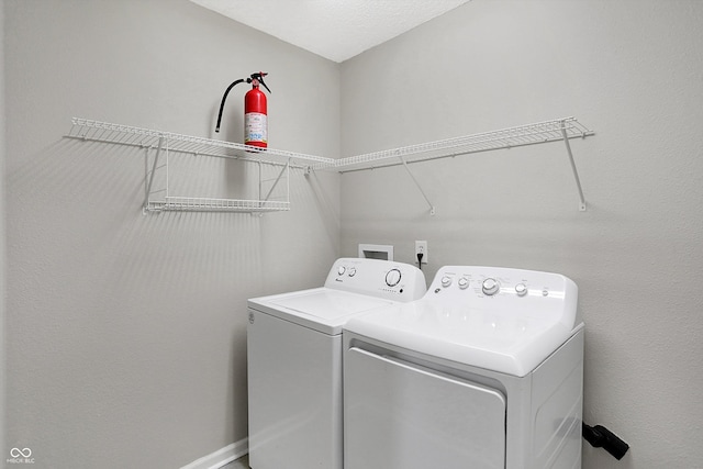 laundry room featuring a textured ceiling and separate washer and dryer