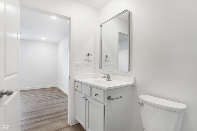 bathroom with vanity, wood-type flooring, and toilet