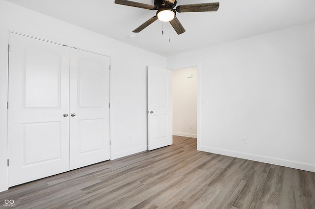 unfurnished bedroom featuring ceiling fan, light hardwood / wood-style flooring, and a closet