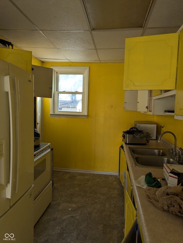 kitchen featuring wood walls, white appliances, a paneled ceiling, and sink