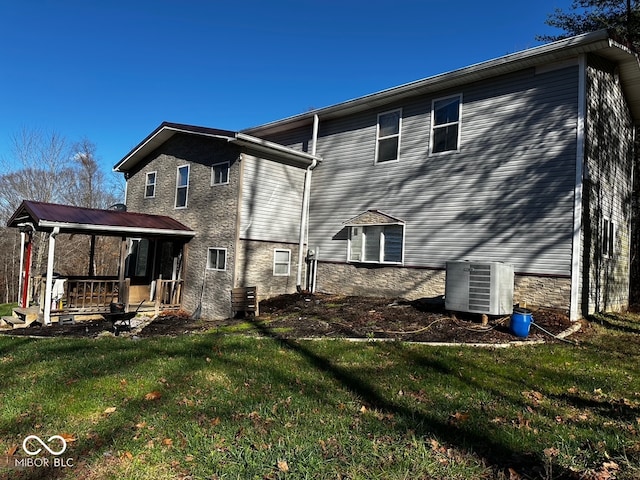 back of property featuring a yard, cooling unit, and a porch