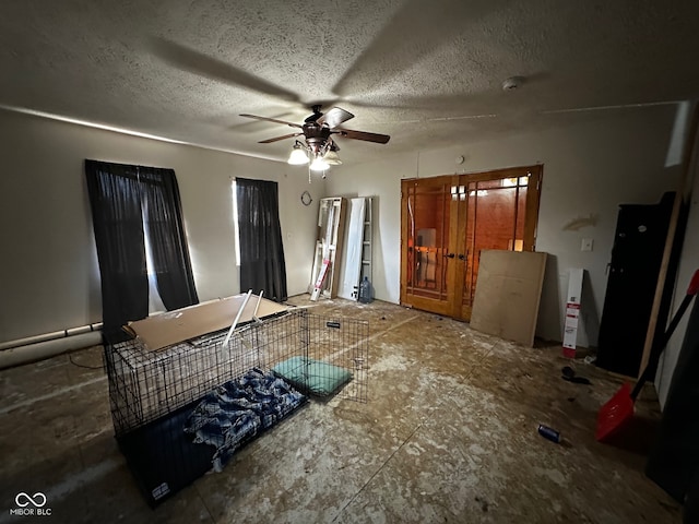 interior space featuring ceiling fan and a textured ceiling