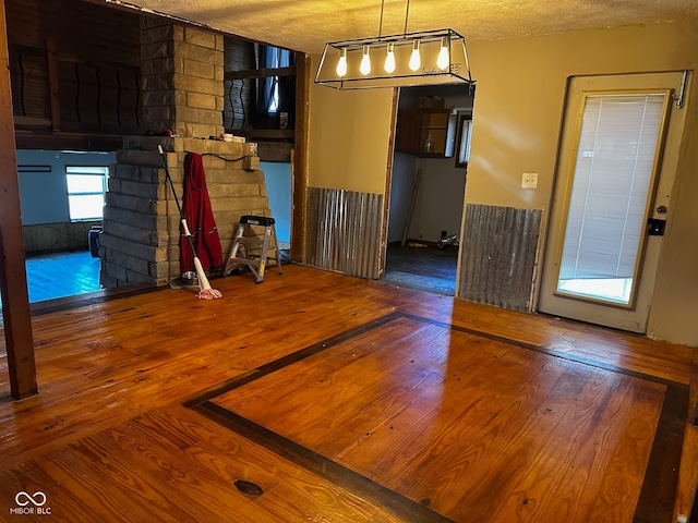 unfurnished dining area with hardwood / wood-style flooring and a textured ceiling