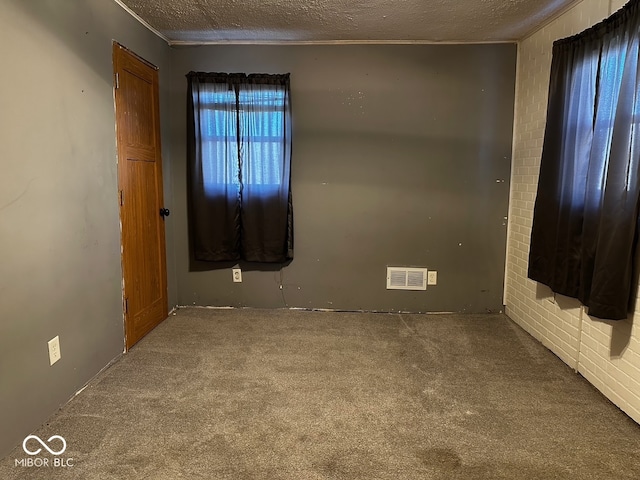 carpeted spare room with a textured ceiling