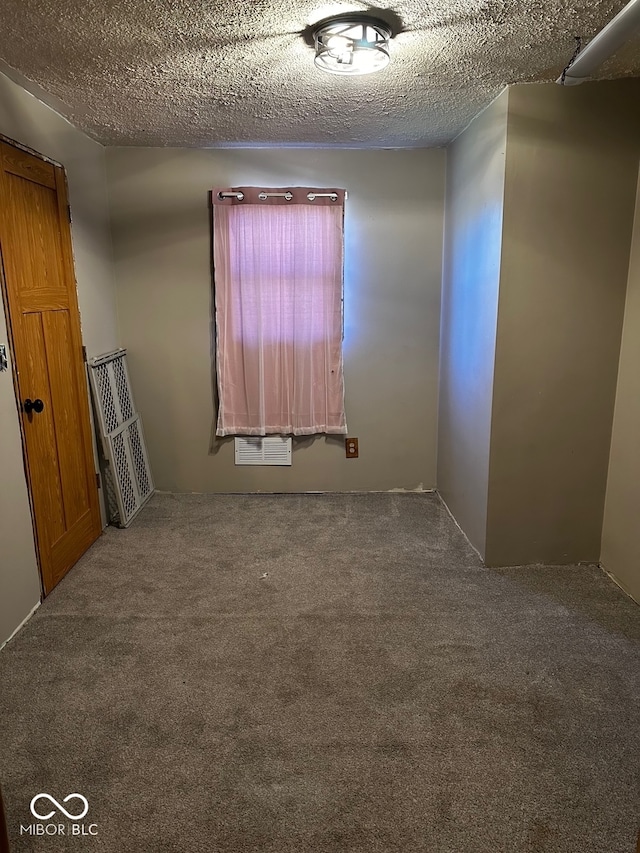 carpeted spare room with a textured ceiling