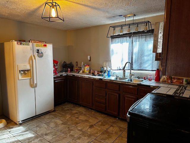 kitchen featuring pendant lighting, range with electric cooktop, white fridge with ice dispenser, and sink