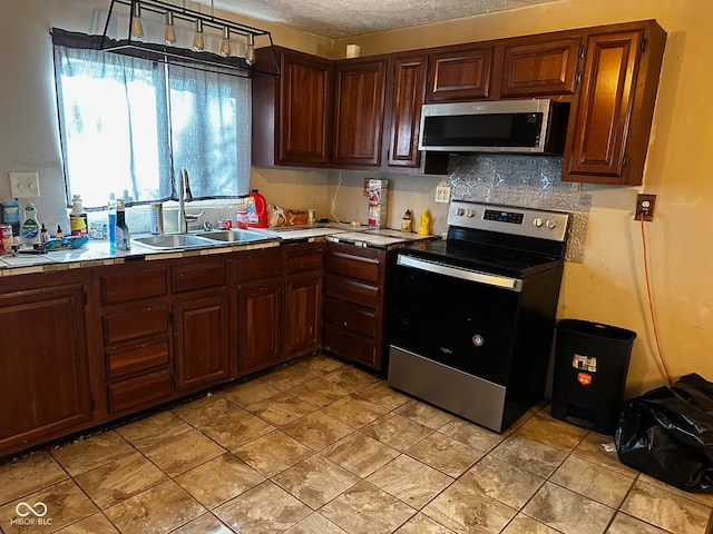 kitchen featuring tasteful backsplash, sink, stainless steel appliances, and a textured ceiling