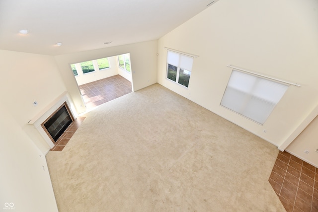 unfurnished living room with carpet flooring and a tiled fireplace