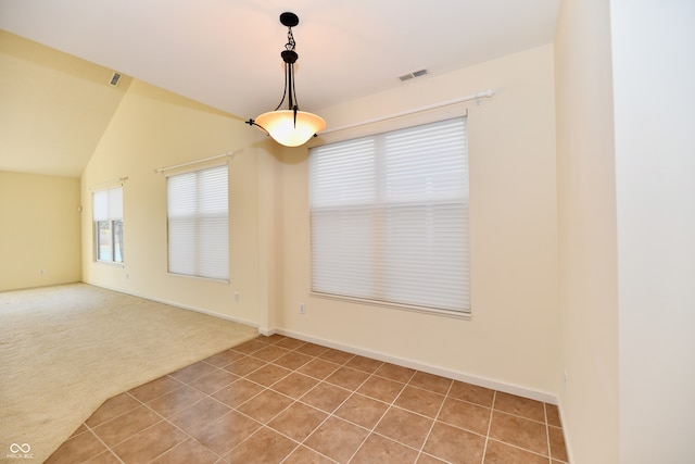 carpeted empty room featuring vaulted ceiling