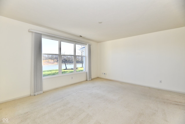 carpeted empty room with a water view