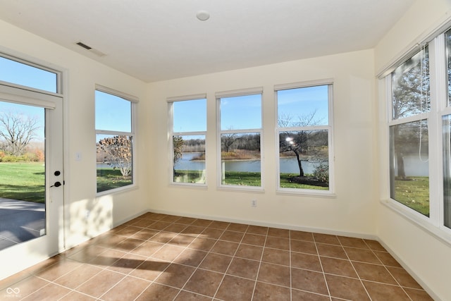 unfurnished sunroom featuring a water view and a wealth of natural light