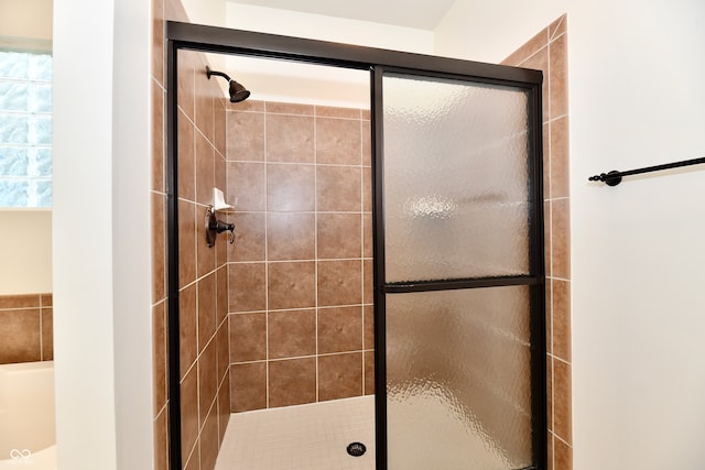 bathroom with a shower with door