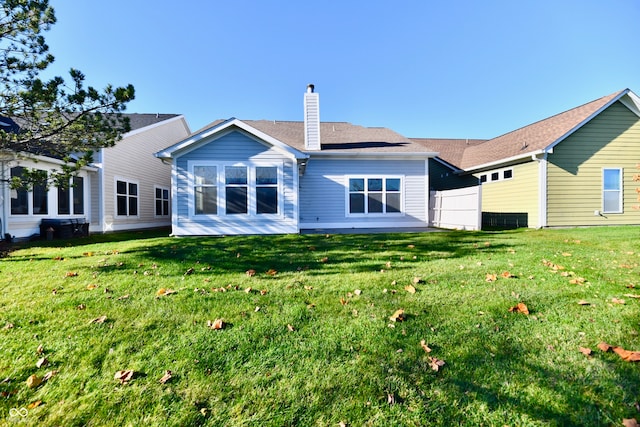 rear view of property with a lawn