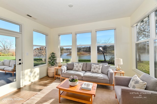 sunroom / solarium featuring a healthy amount of sunlight and a water view