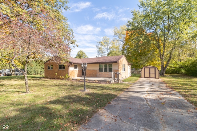 view of front of home with a front yard and a shed