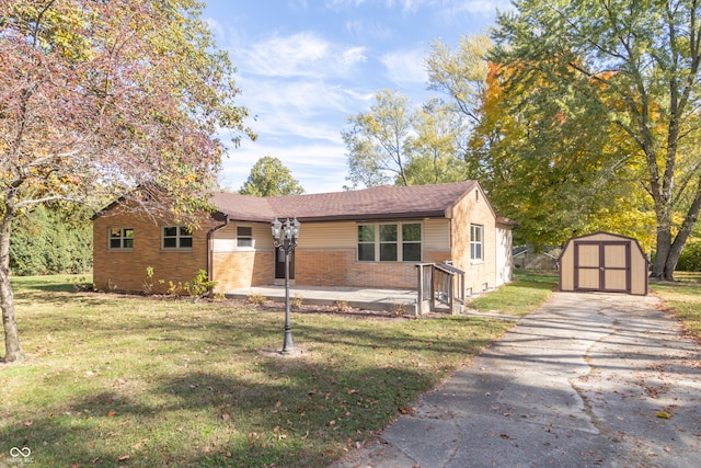 view of front facade with a front lawn, a storage unit, and a patio area