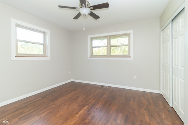 unfurnished bedroom featuring dark hardwood / wood-style flooring, a closet, and ceiling fan