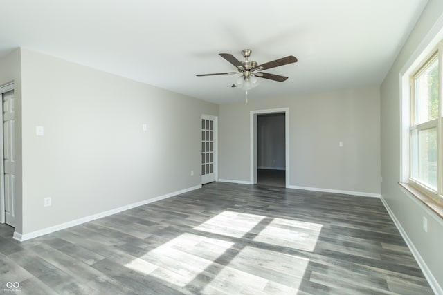 unfurnished room with ceiling fan and dark wood-type flooring