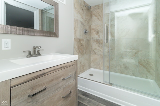 bathroom featuring hardwood / wood-style floors, vanity, and shower / bath combination with glass door