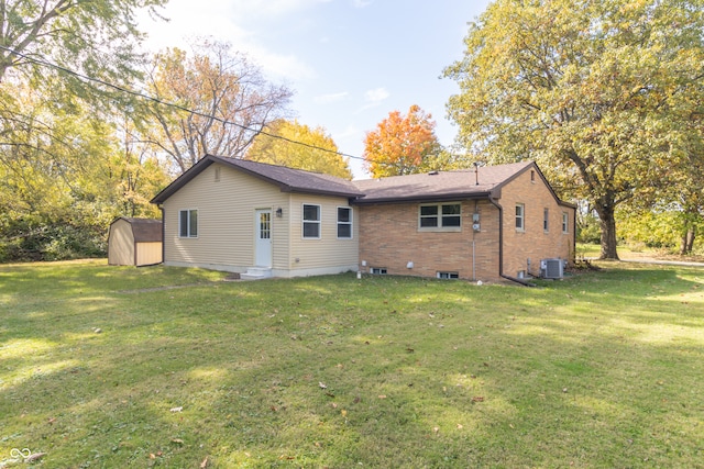 back of property with a lawn, a storage unit, and cooling unit