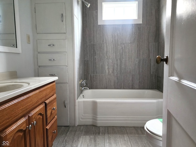 full bathroom with vanity, toilet, wood-type flooring, and tiled shower / bath