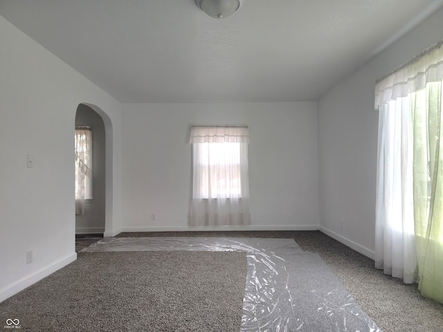 spare room featuring dark carpet