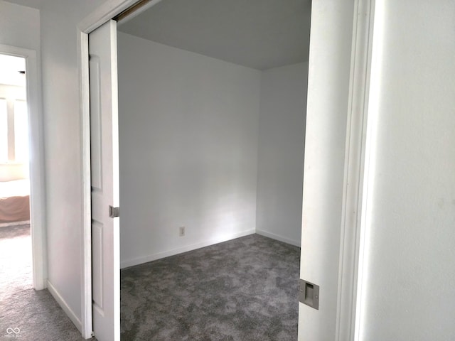 spare room with dark carpet