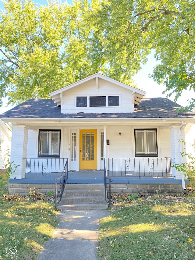 view of front facade featuring covered porch and a front yard