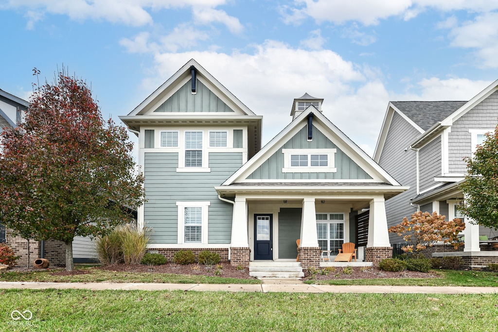 craftsman house with covered porch and a front yard