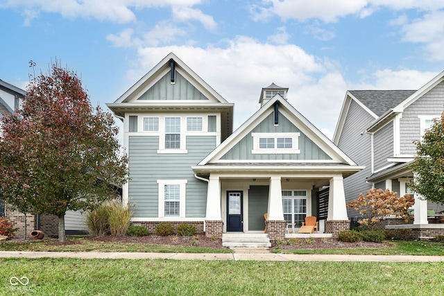 craftsman house with covered porch and a front yard