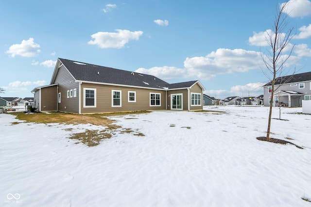 view of snow covered back of property