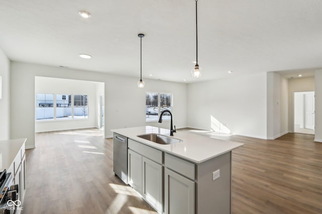 kitchen with stainless steel appliances, gray cabinetry, a kitchen island with sink, pendant lighting, and sink