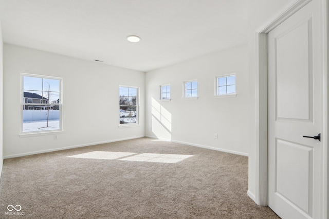 carpeted empty room with a healthy amount of sunlight