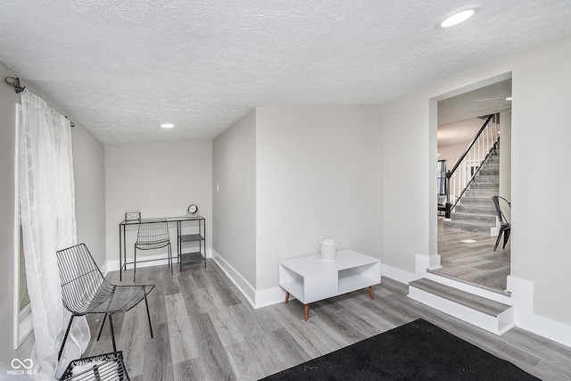 living area featuring light hardwood / wood-style flooring and a textured ceiling