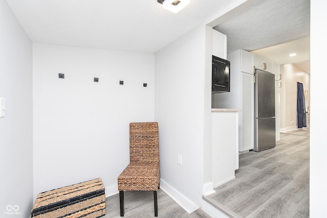 mudroom with light hardwood / wood-style flooring and a textured ceiling