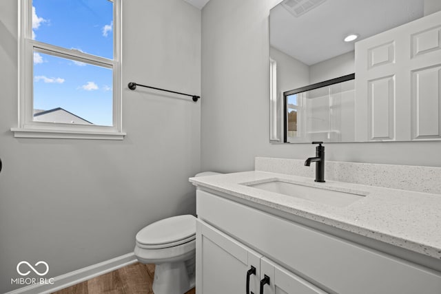 bathroom featuring hardwood / wood-style flooring, vanity, toilet, and an enclosed shower