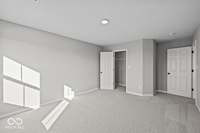 unfurnished bedroom featuring light carpet and a closet