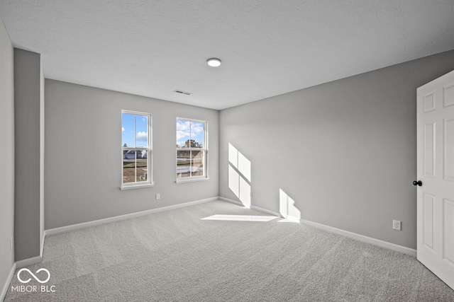 carpeted spare room with a textured ceiling