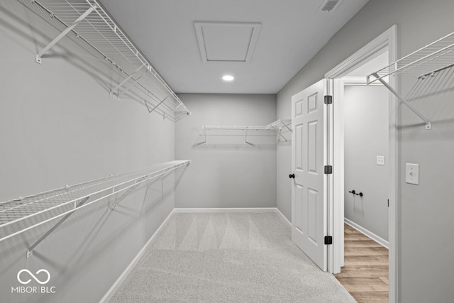 walk in closet with hardwood / wood-style floors