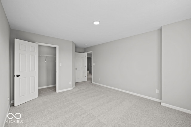 unfurnished bedroom with light colored carpet and a closet