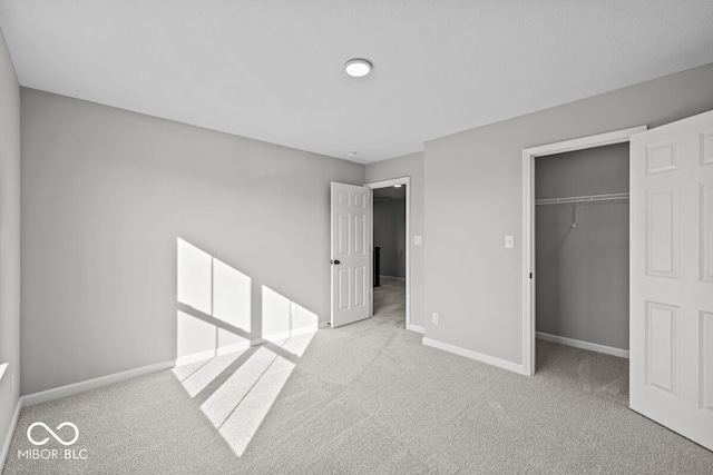 unfurnished bedroom with light colored carpet and a closet