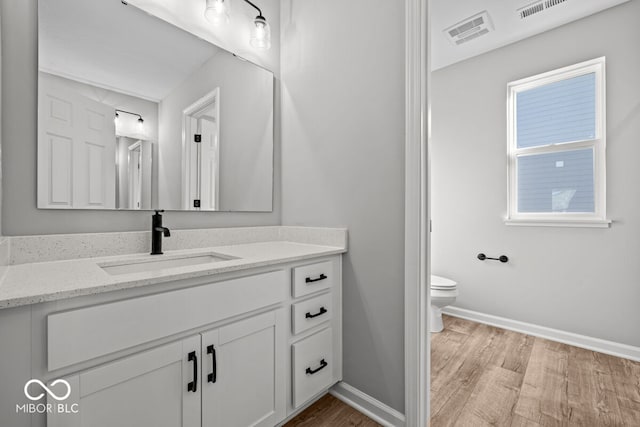 bathroom featuring hardwood / wood-style floors, vanity, and toilet