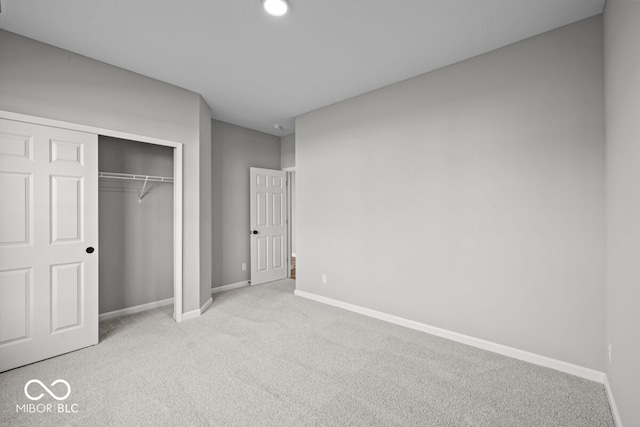 unfurnished bedroom featuring a closet and light colored carpet